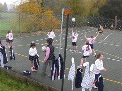 players on netball courts through the fencing