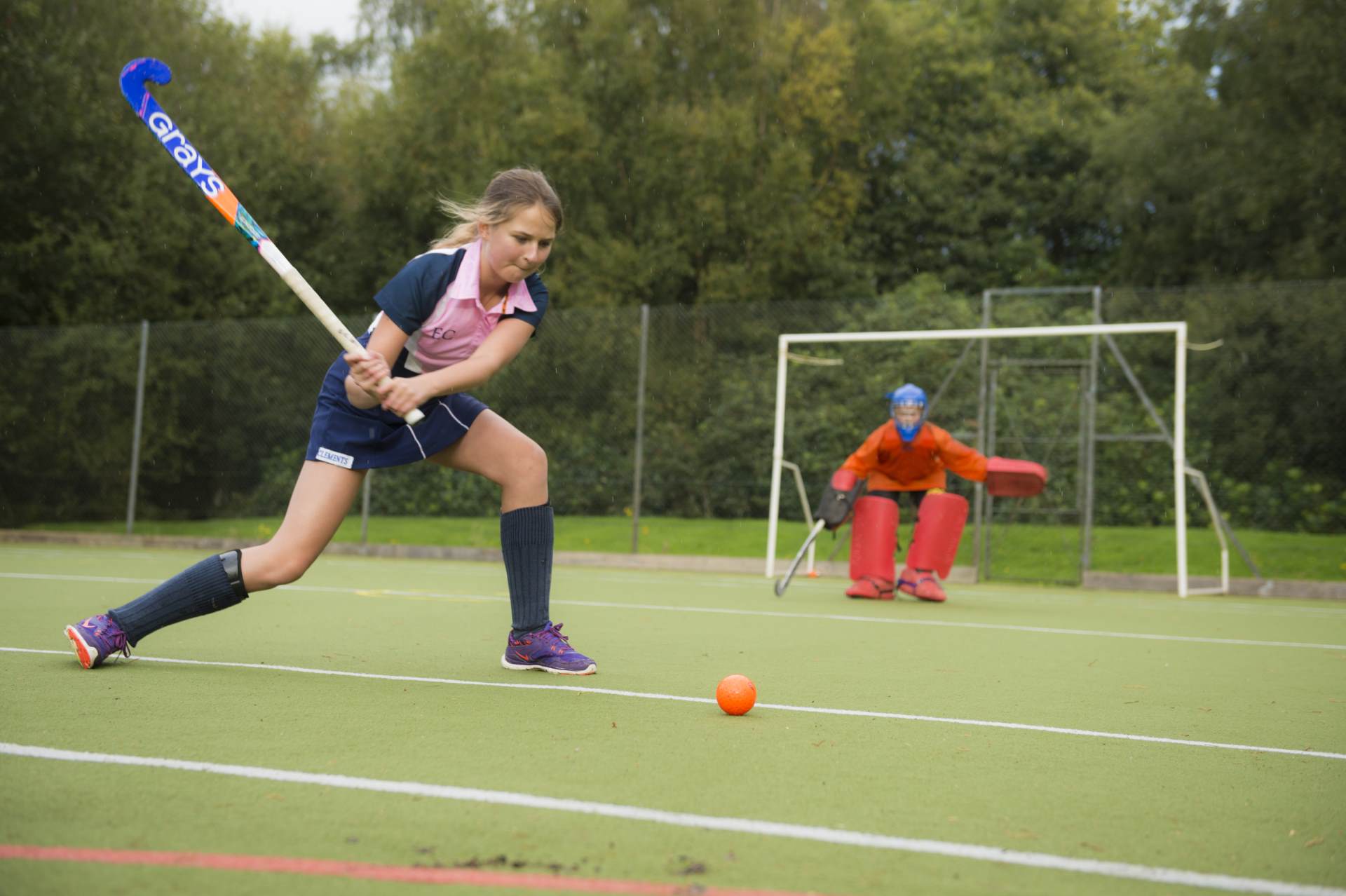 girl on hockey pitch shooting at goal